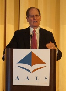 Benjamin Heineman stands speaking behind a podium with the AALS logo